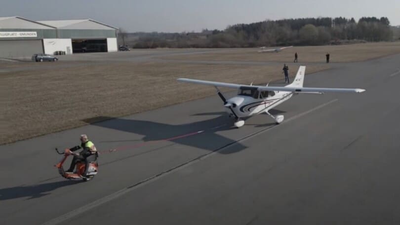 Con la Vespa (e su una ruota) traina un aereo: il record di Schachermayr