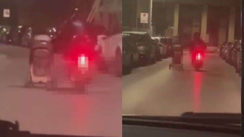 Spinge un passeggino di notte dalla sella di uno scooter: il video shock