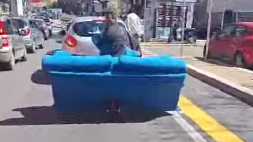 Trasporta un divano sul monopattino: la scena incredibile nel traffico di Roma