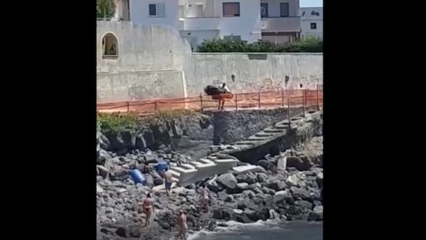 Becca la ragazza con l'amante, gli butta lo scooter sugli scogli